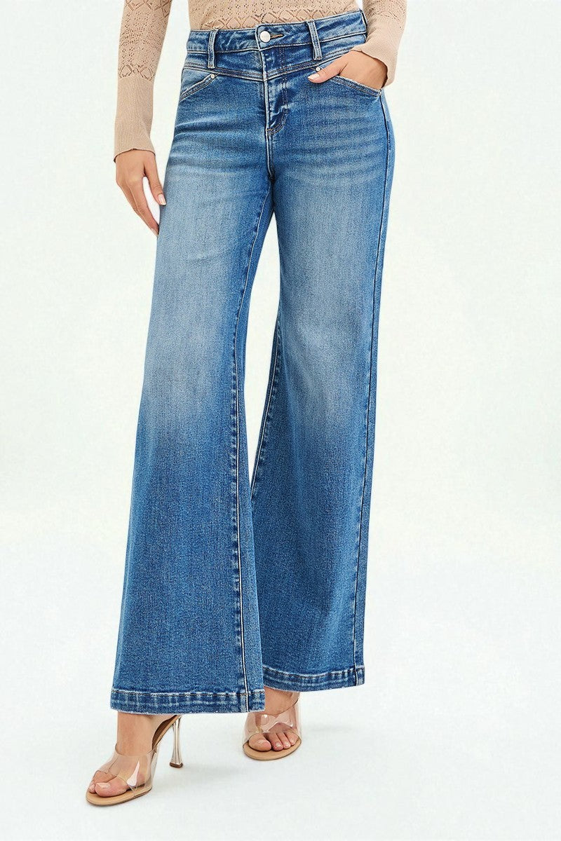 Person wearing blue flared jeans on a white background