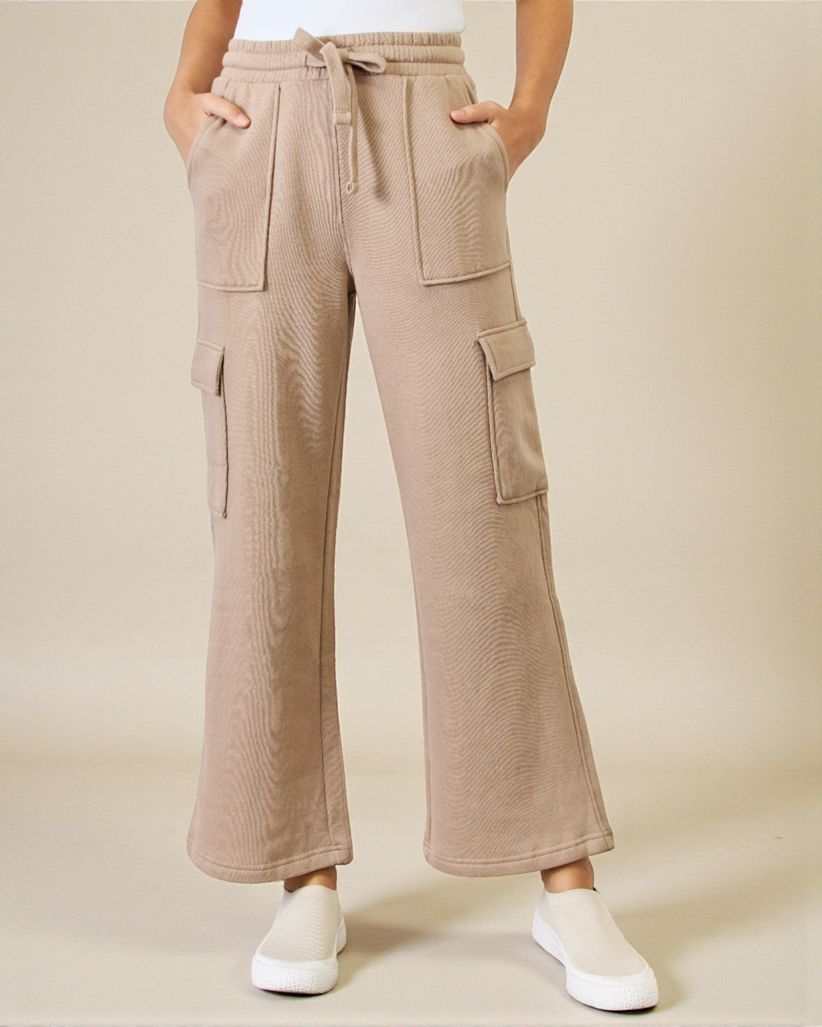 Beige cargo pants worn by a person on a beige background