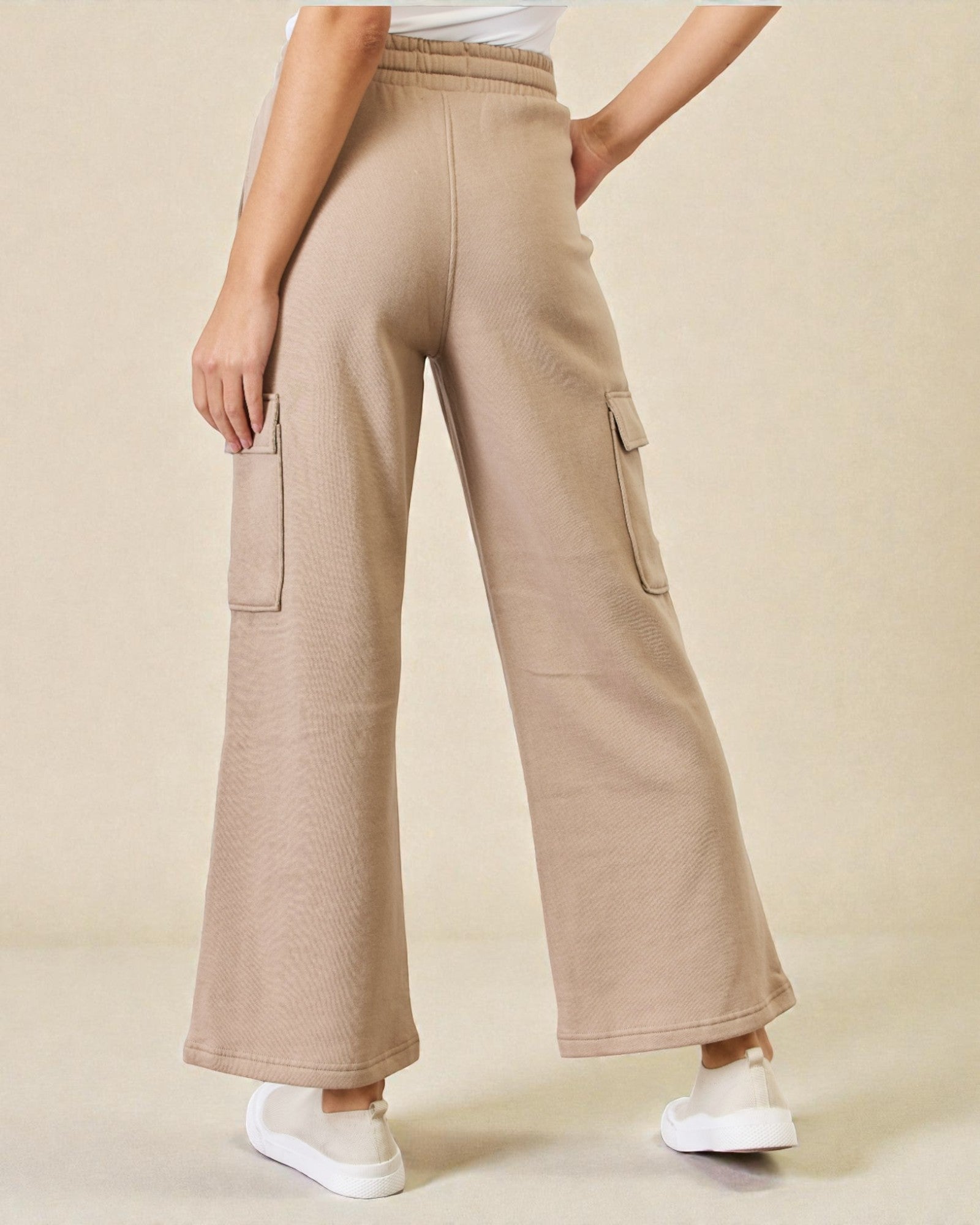 Beige cargo pants worn by a person on a beige background