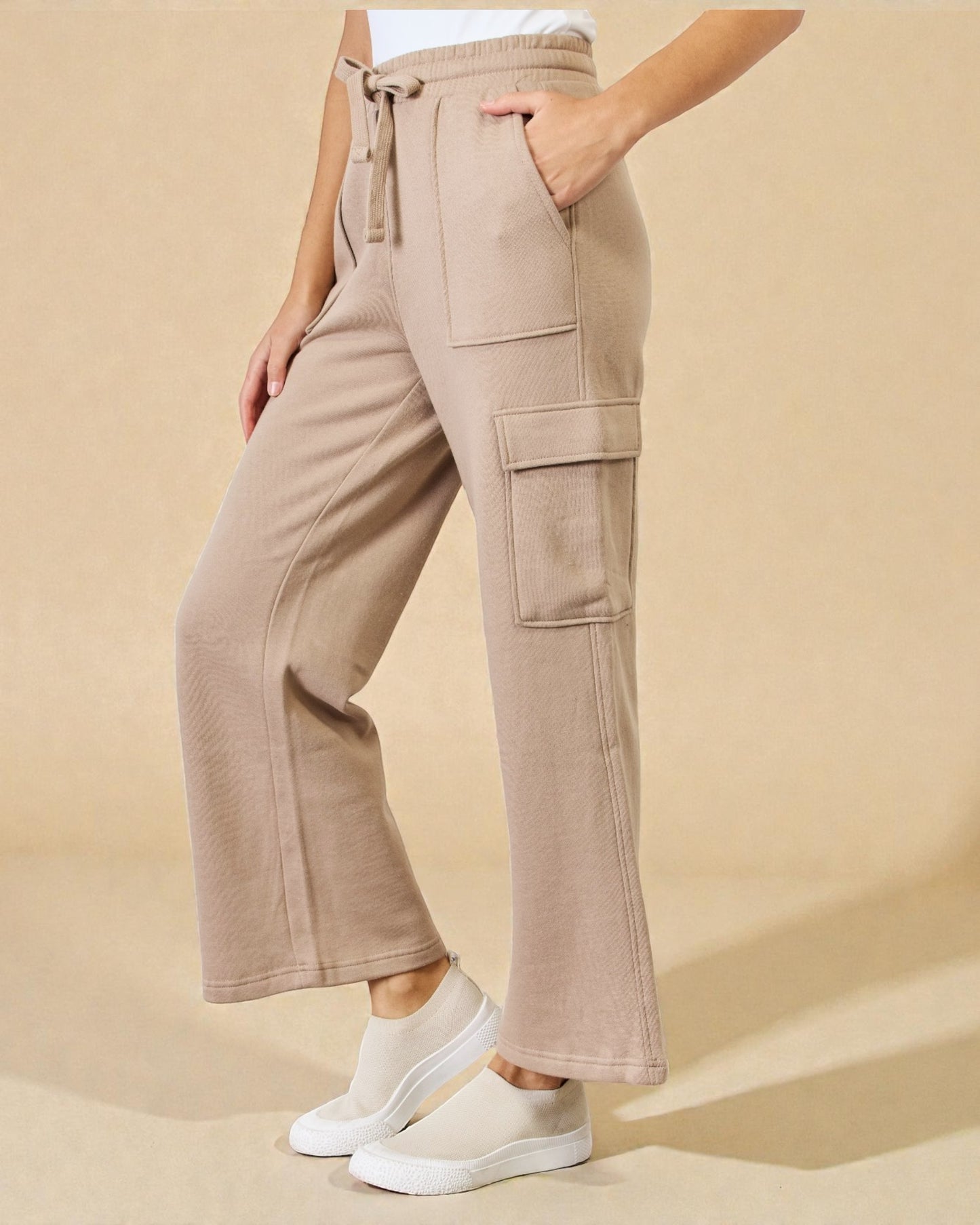 Beige cargo pants worn by a person on a beige background