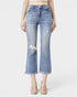 Person wearing distressed blue jeans on a white background