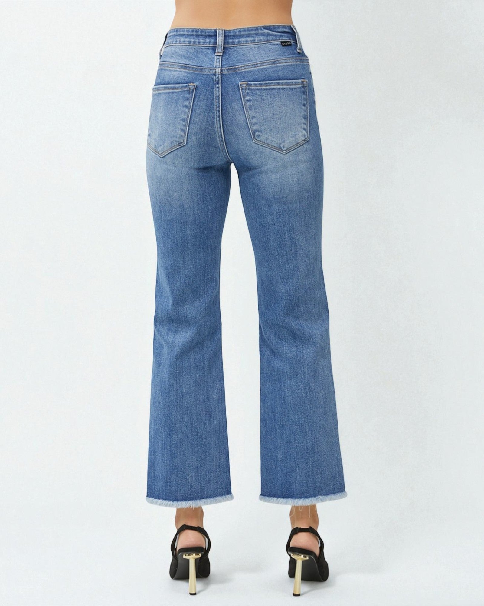 Blue jeans worn by a person on a white background