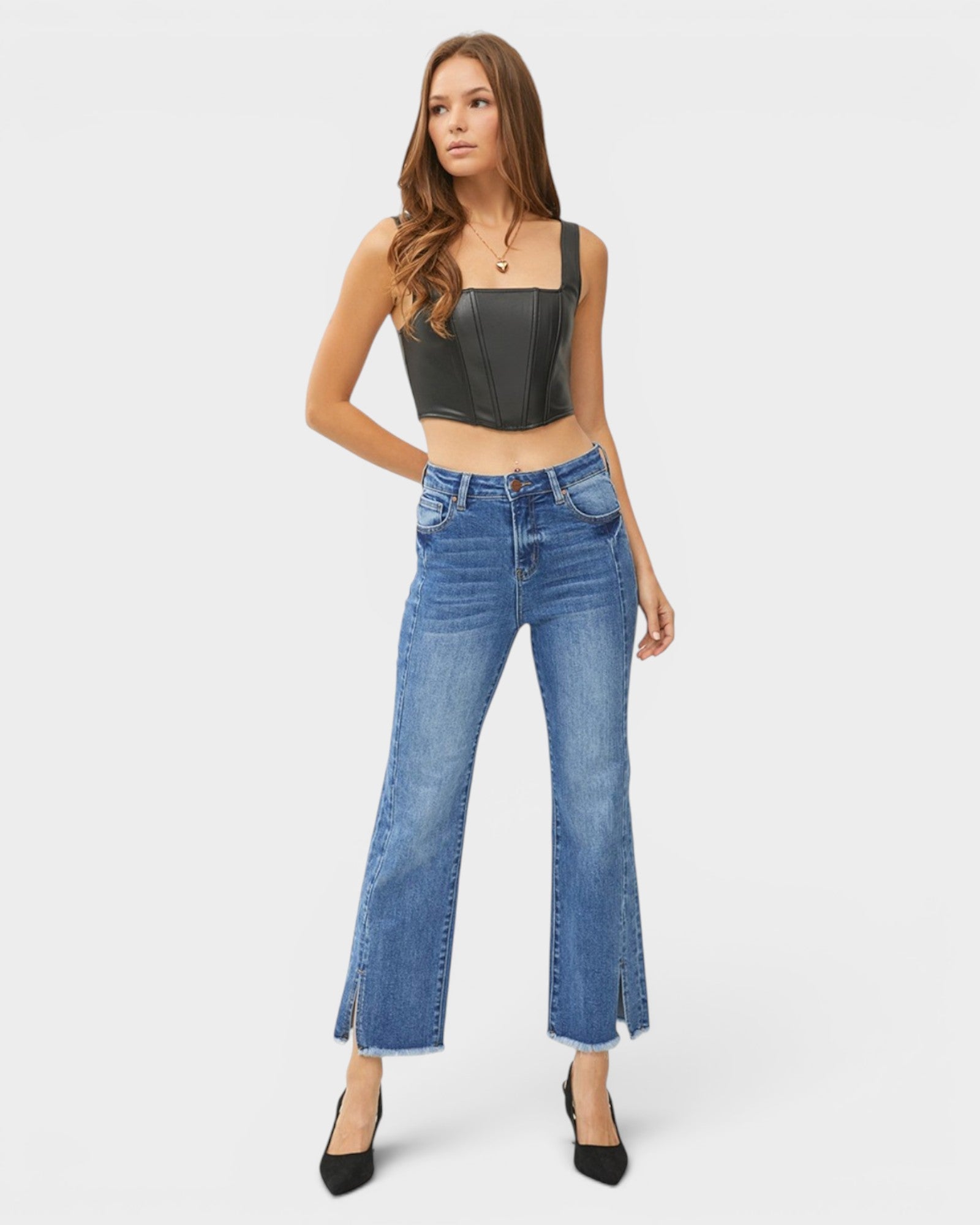 Woman wearing a black crop top and blue jeans on a white background