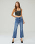 Woman wearing a black leather top and blue jeans on a white background