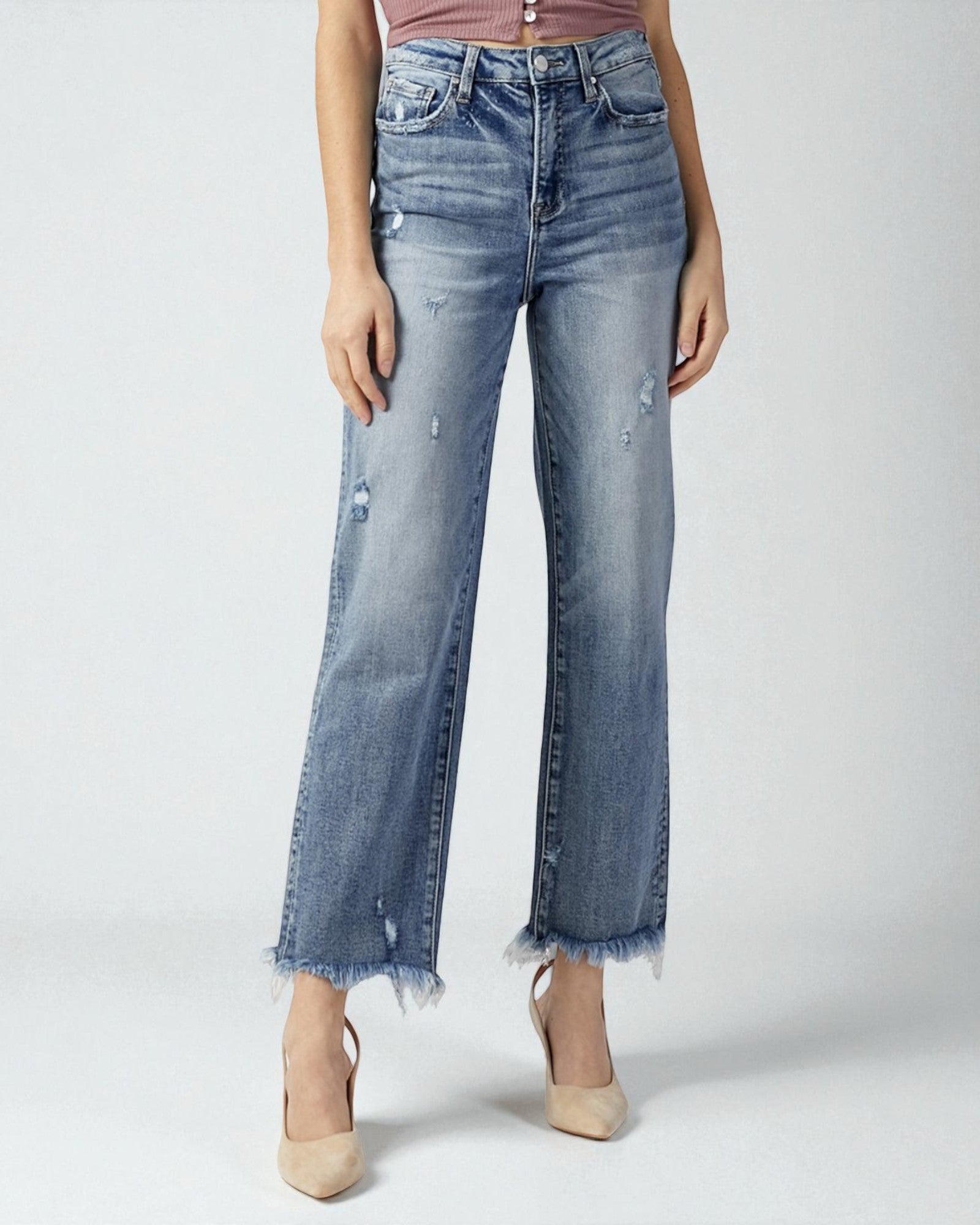 Person wearing light blue distressed jeans on a white background