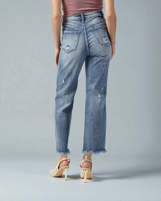 Person wearing light blue distressed jeans on a gray background