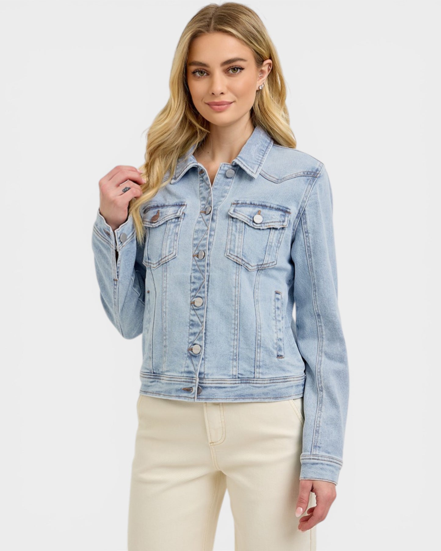 Woman wearing a light blue denim jacket on a white background