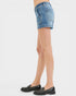 Denim shorts worn by a person on a white background