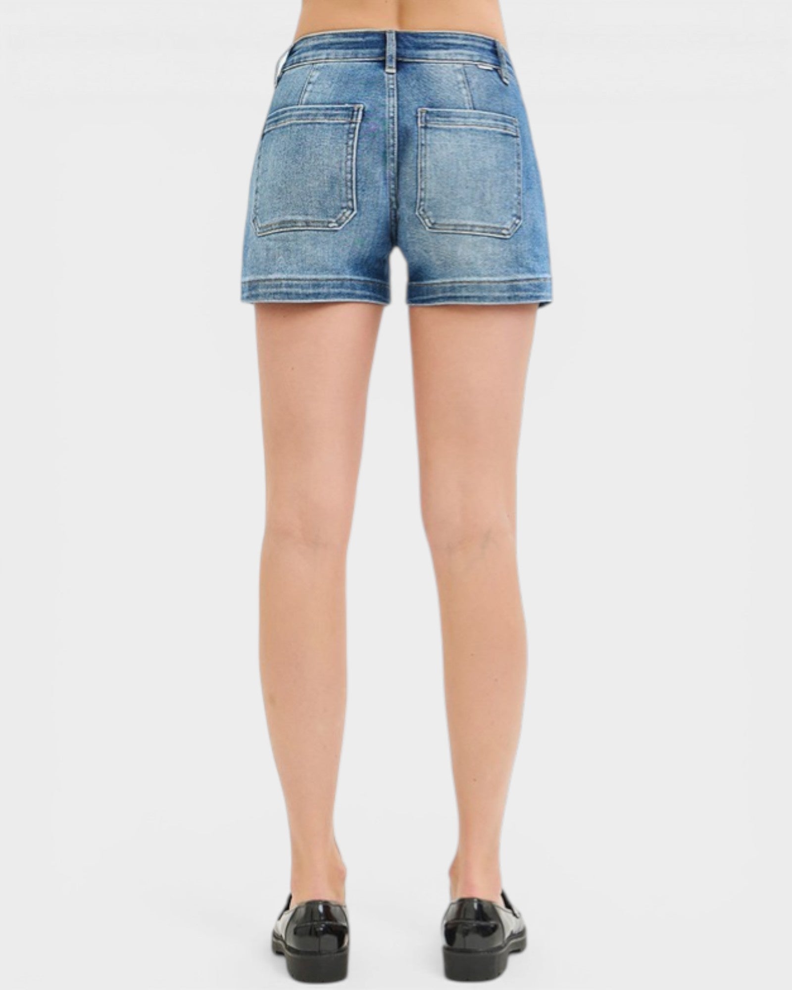 Denim shorts worn by a person on a white background