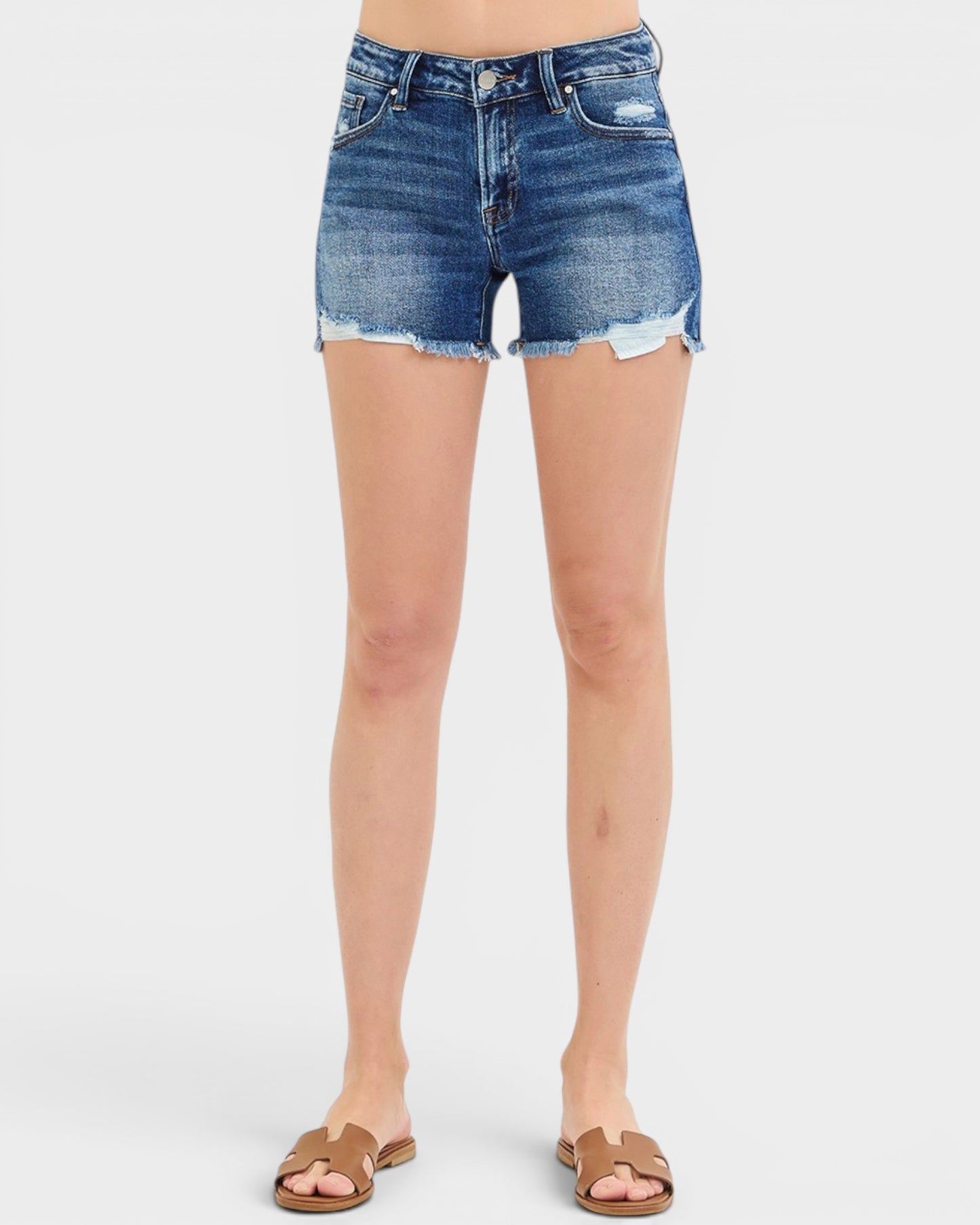 Denim shorts worn by a person on a white background