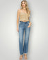 Woman wearing a beige strapless top and blue jeans on a plain background