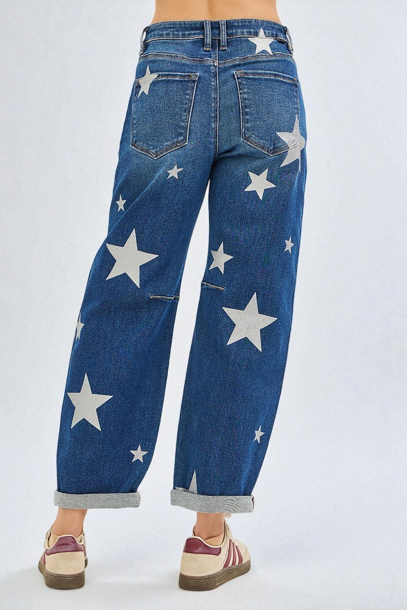 Blue jeans with star patterns worn by a person on a white background