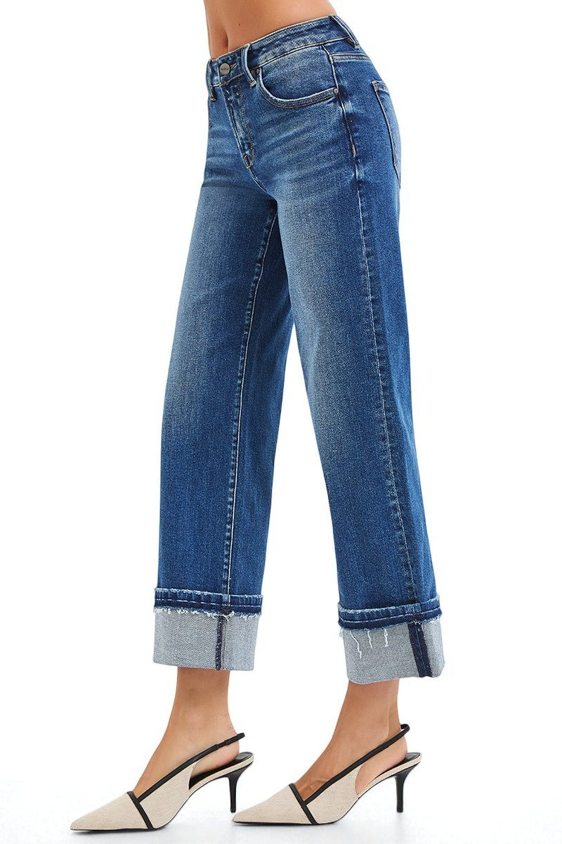 Blue jeans with rolled-up cuffs on a white background