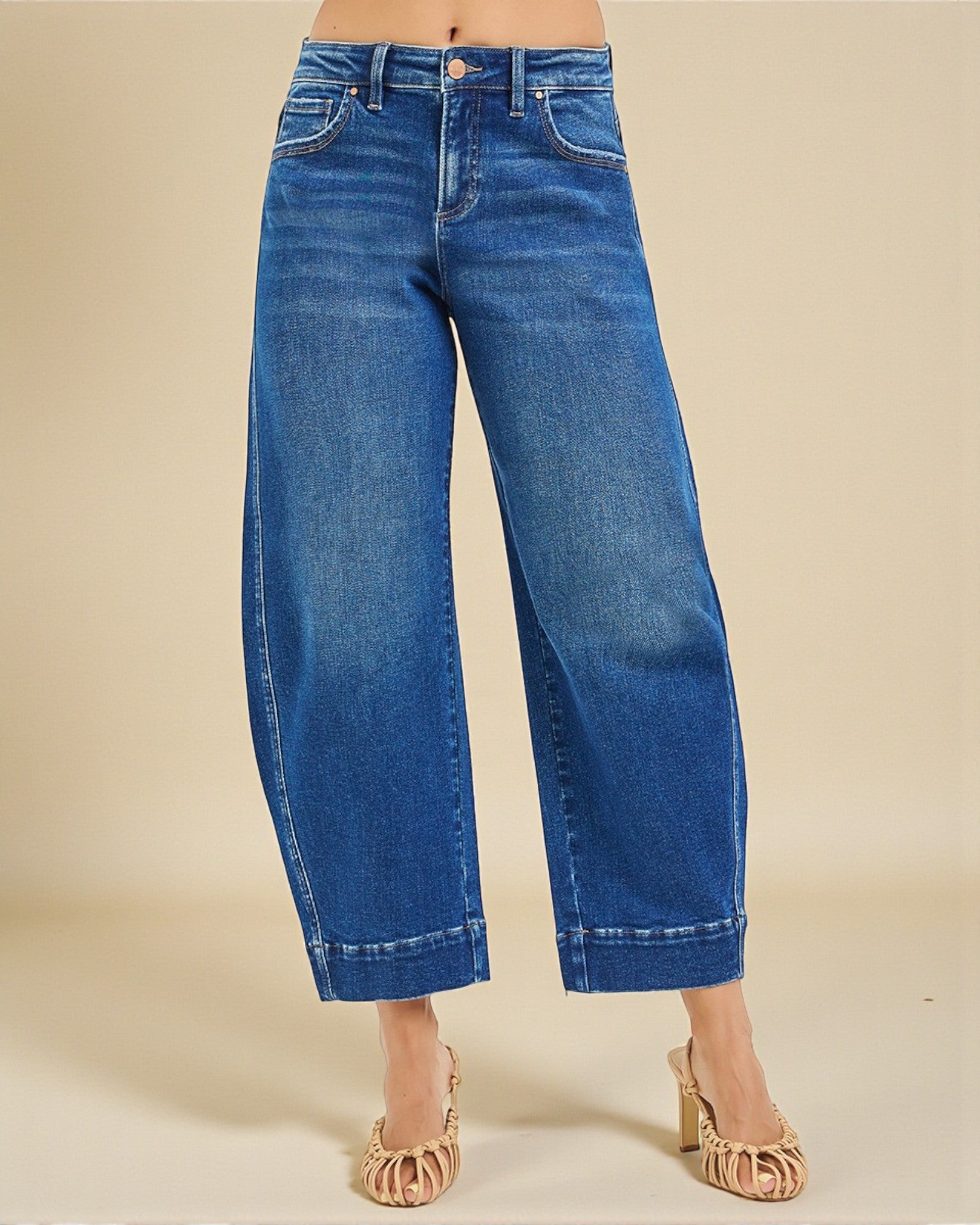 Blue jeans worn by a person on a beige background