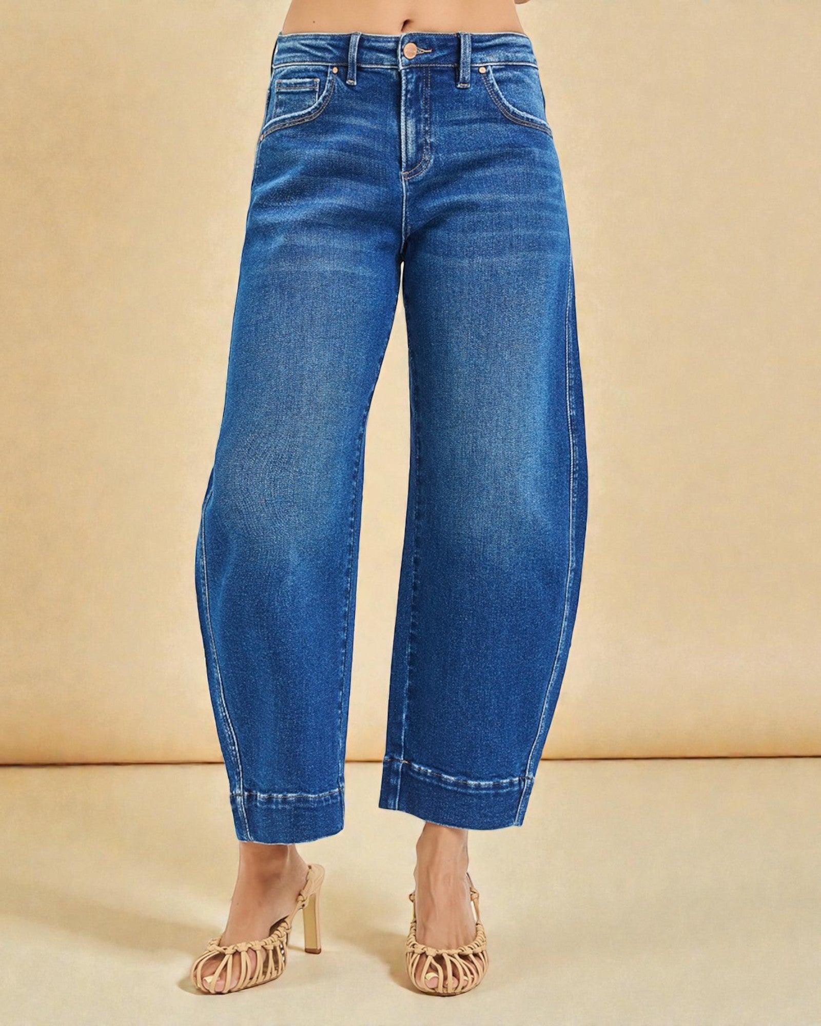 Blue jeans worn by a person on a beige background