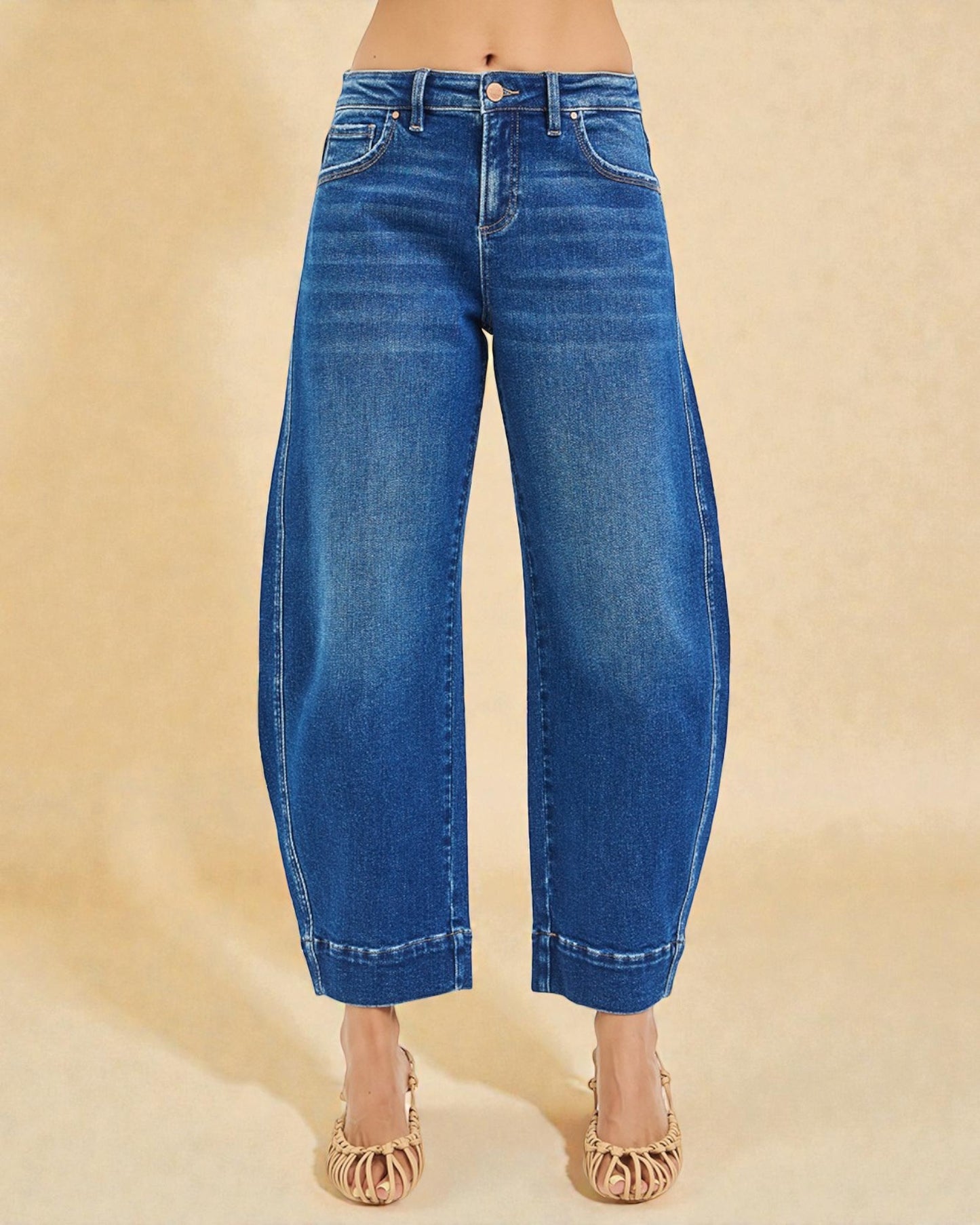 Blue jeans worn by a person on a beige background