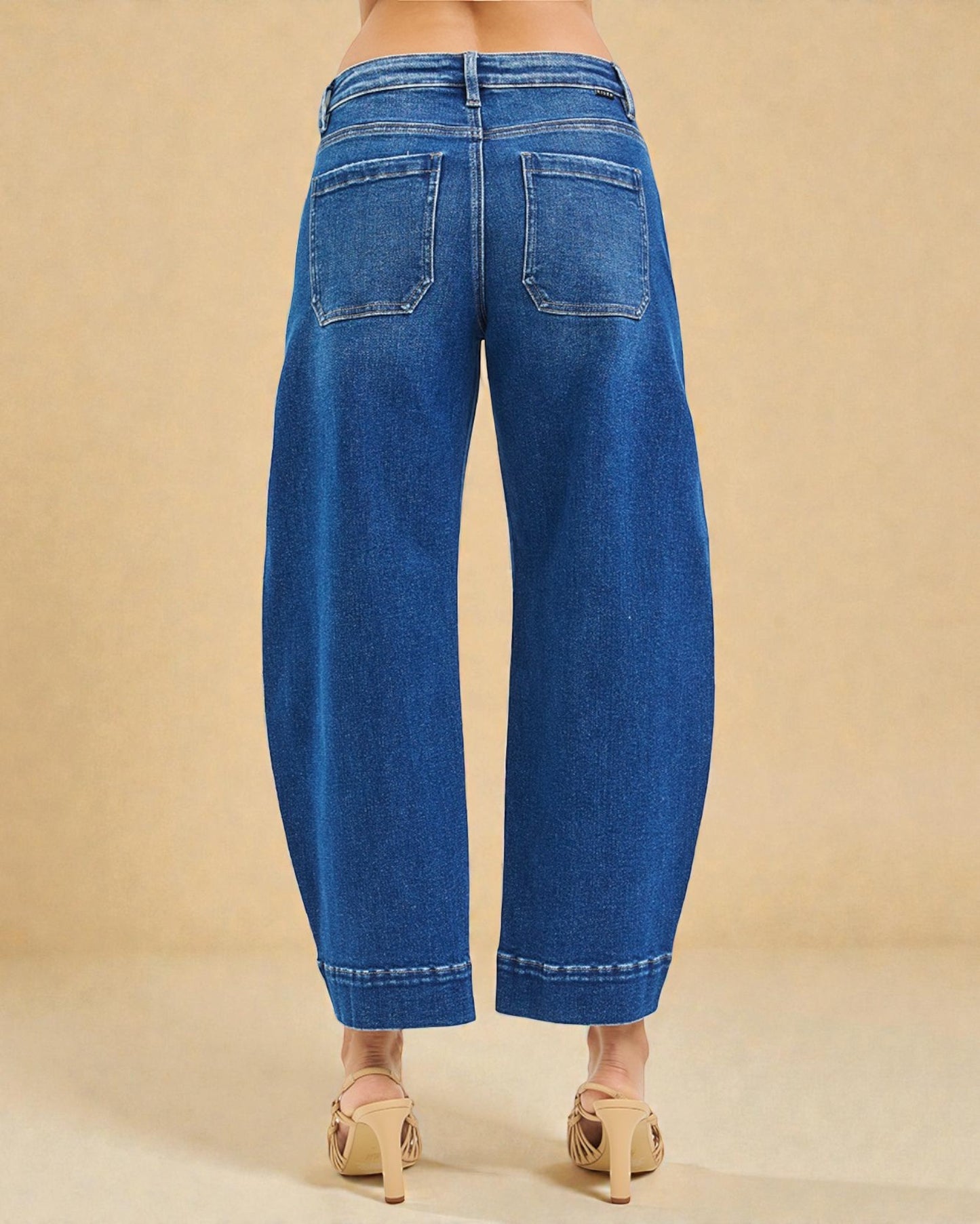 Blue jeans worn by a person on a beige background