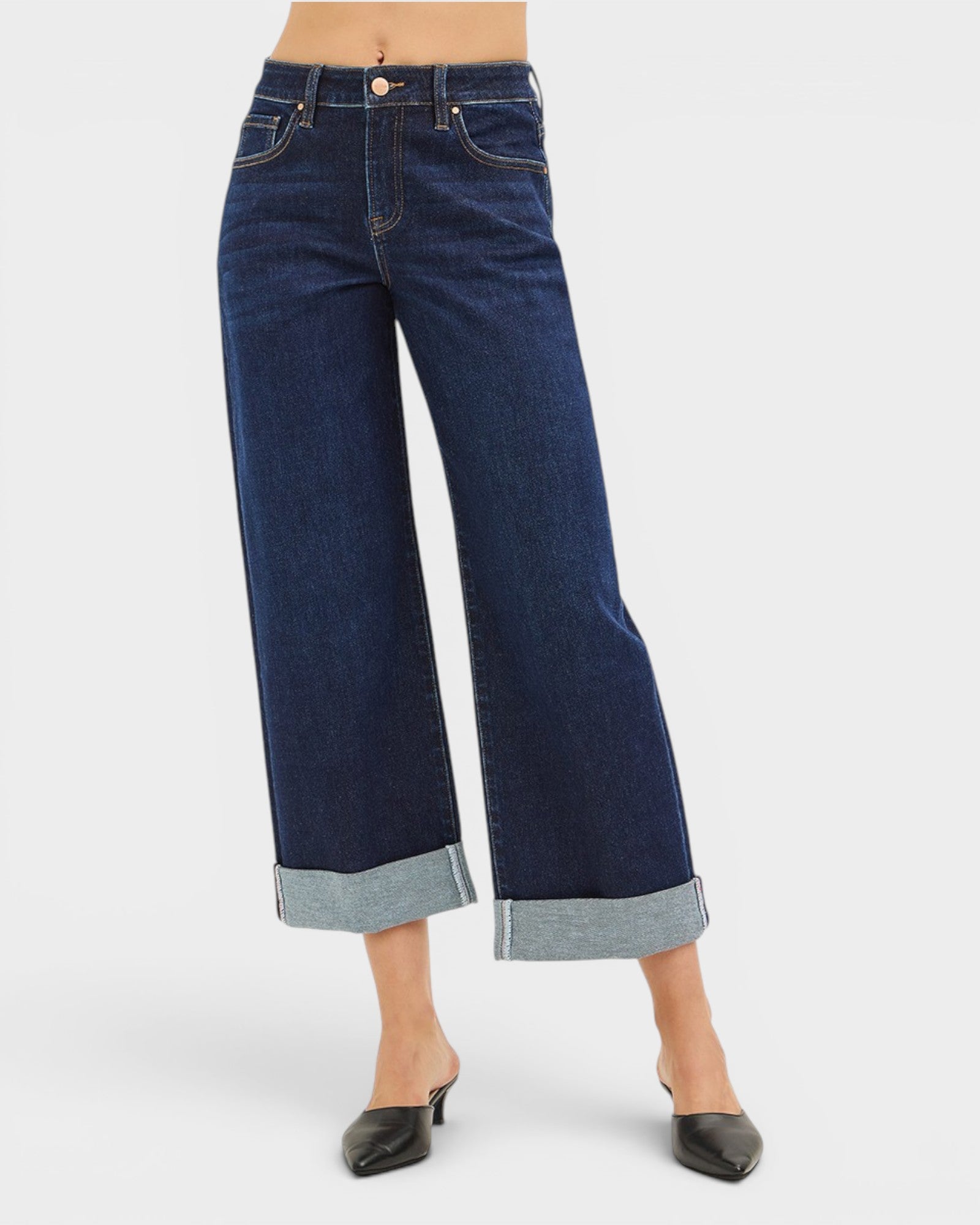 Dark blue wide-leg jeans worn by a person on a white background