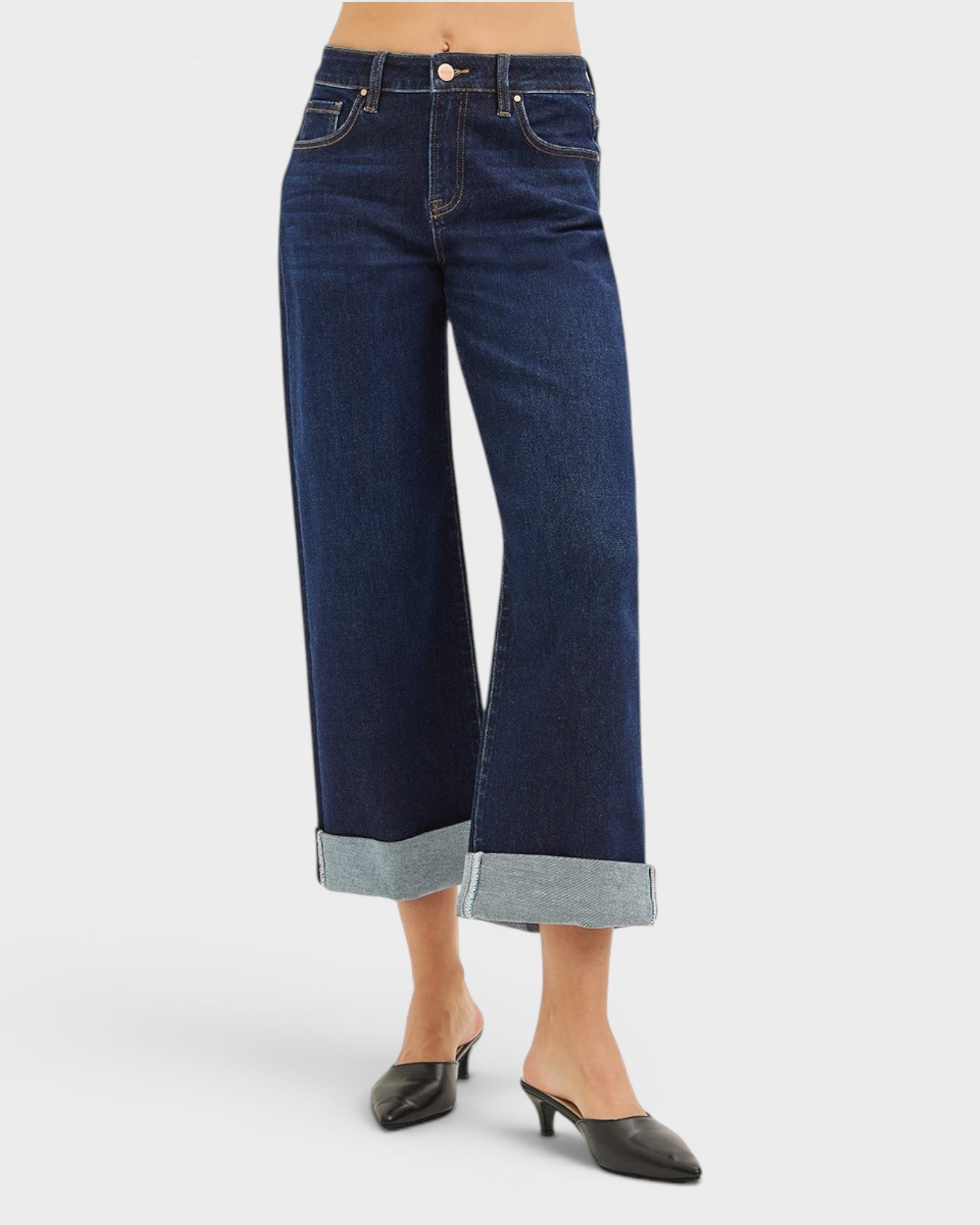 Dark blue wide-leg jeans with rolled-up hem on a white background