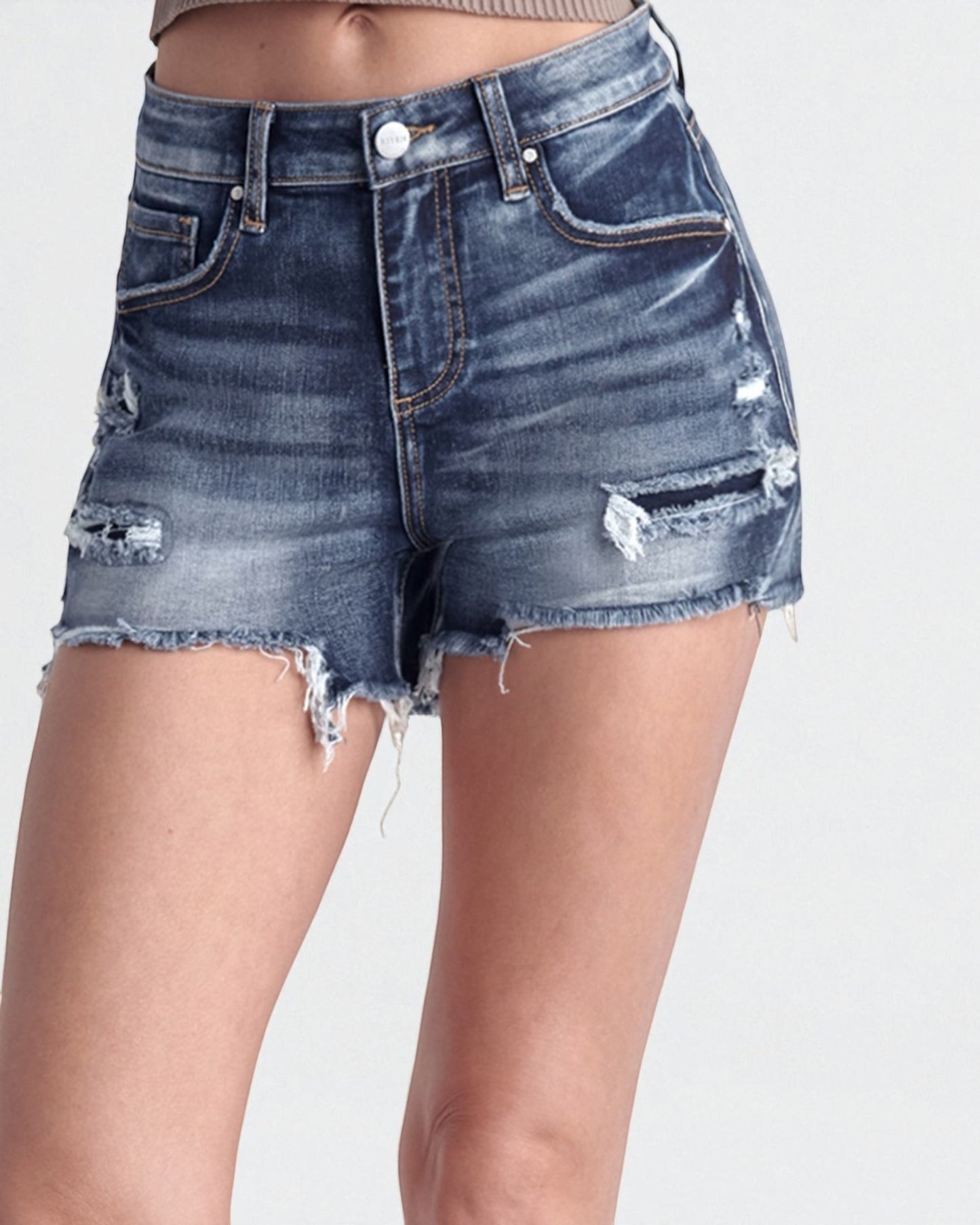 Denim shorts with distressed details on a white background