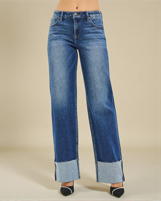 Blue jeans with cuffed hems on a beige background