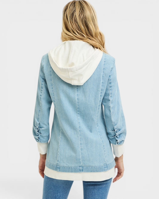 Light blue denim jacket with white hoodie worn by a person on a light gray background