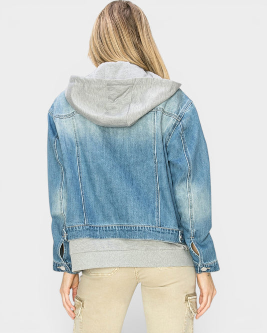 Person wearing a blue denim jacket with a gray hoodie on a white background