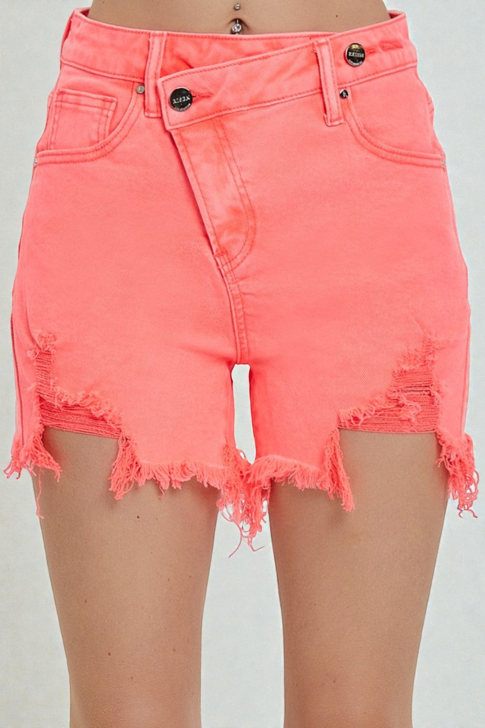 Coral shorts with frayed edges on a plain background