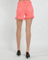 Coral denim shorts worn by a person on a white background