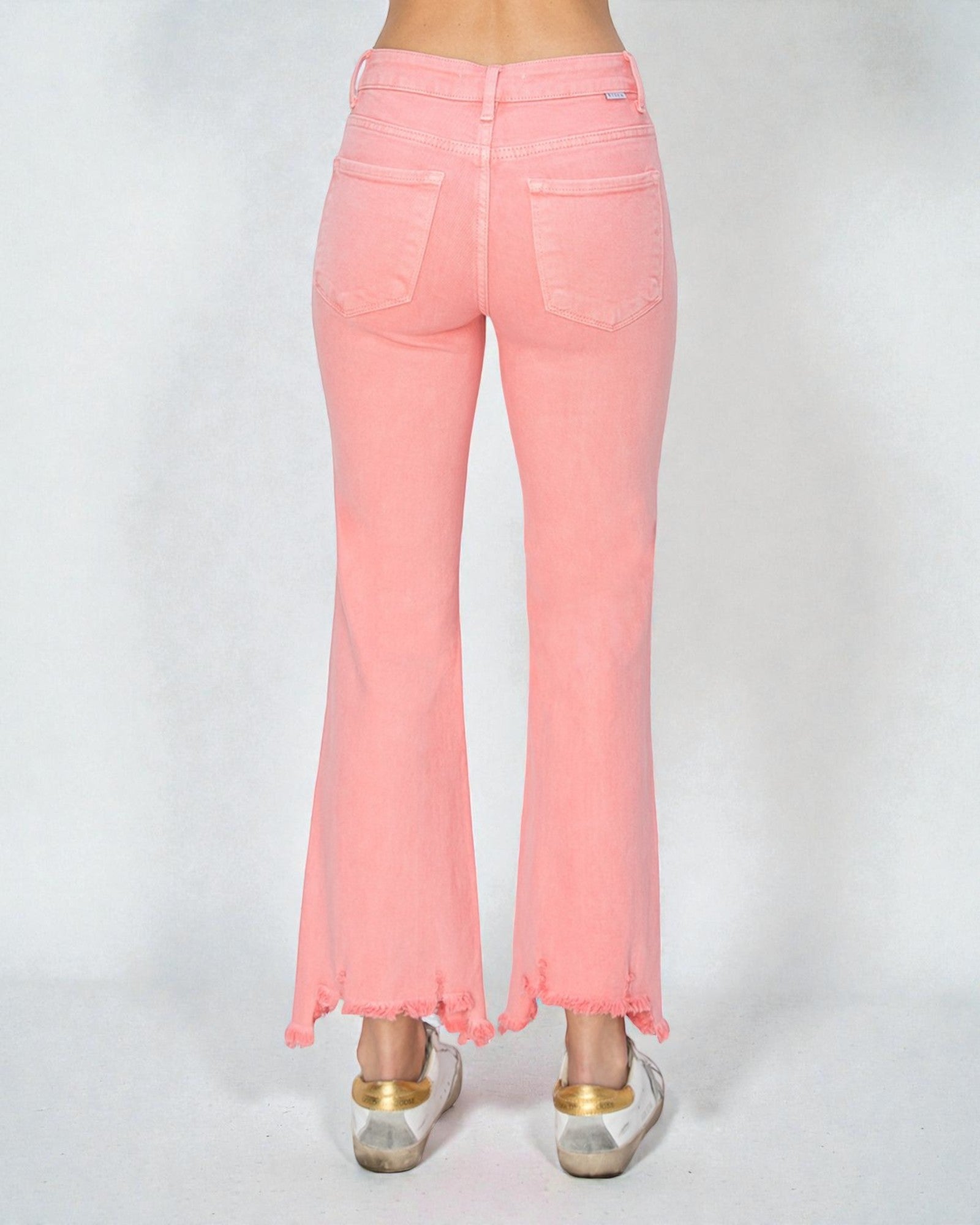 Pink jeans worn by a person on a white background