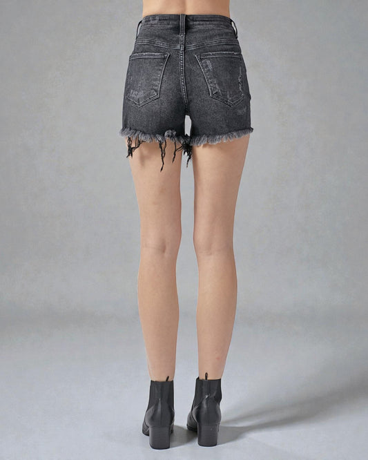 Black denim shorts worn by a person on a gray background