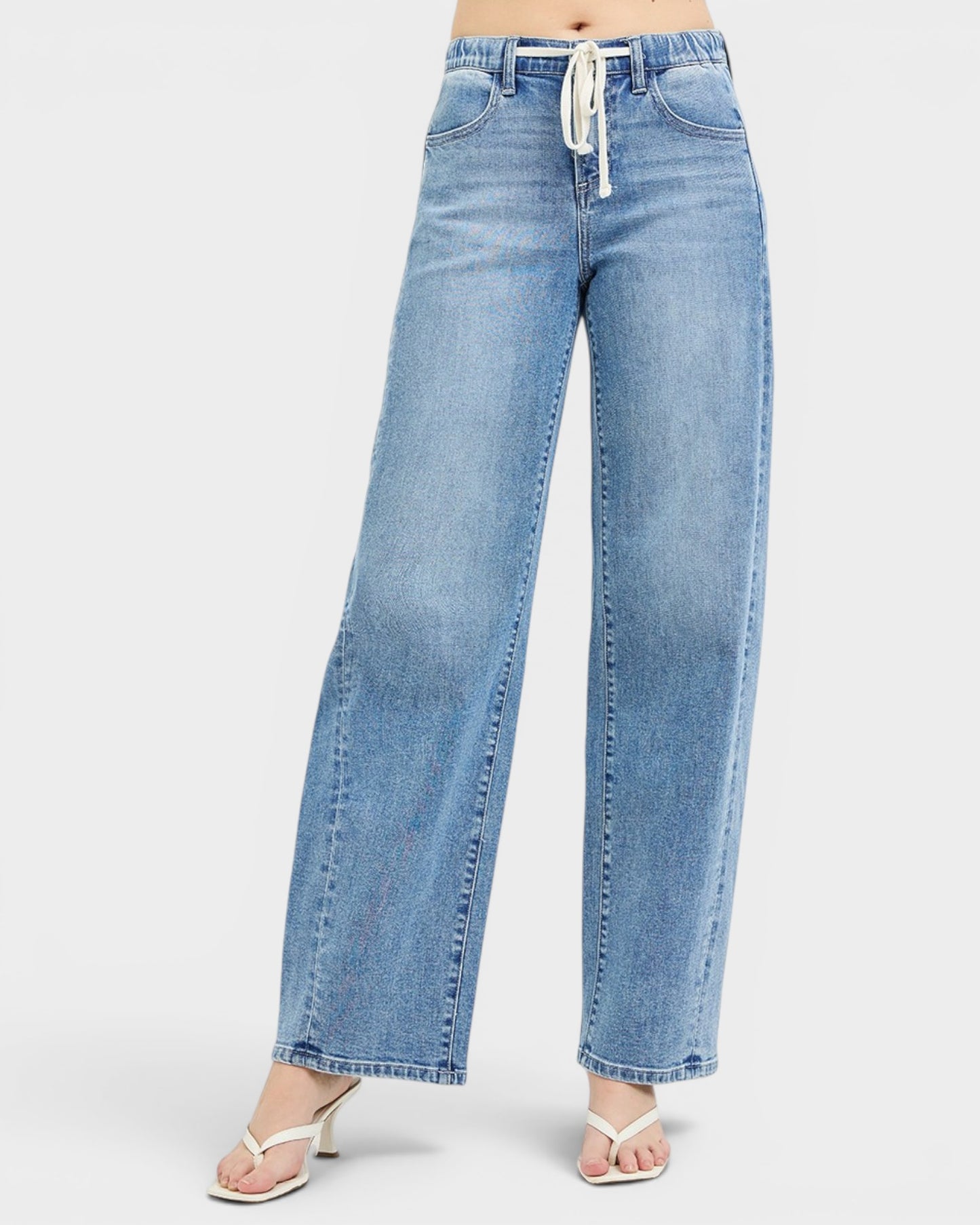 Light blue jeans worn by a person on a white background