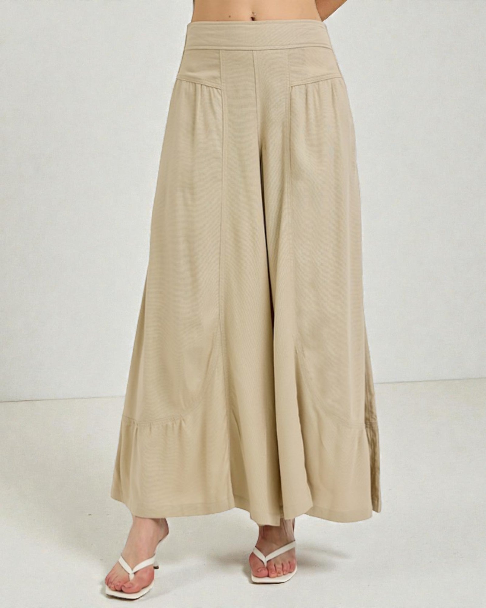 Beige wide-leg pants worn by a person on a white background