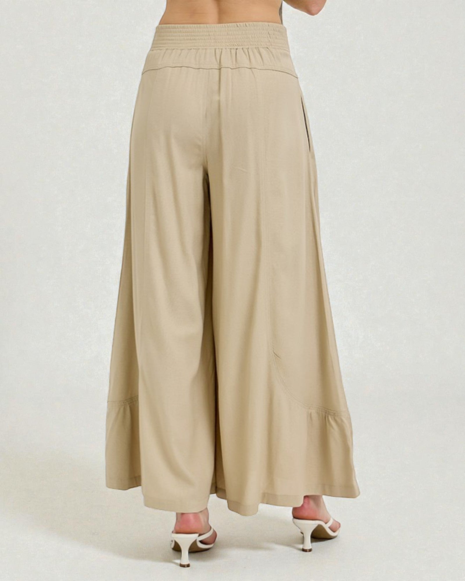 Beige wide-leg pants worn by a person on a white background