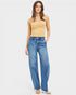 Woman wearing blue jeans and a beige top on a white background