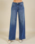 Blue jeans worn by a person on a beige background