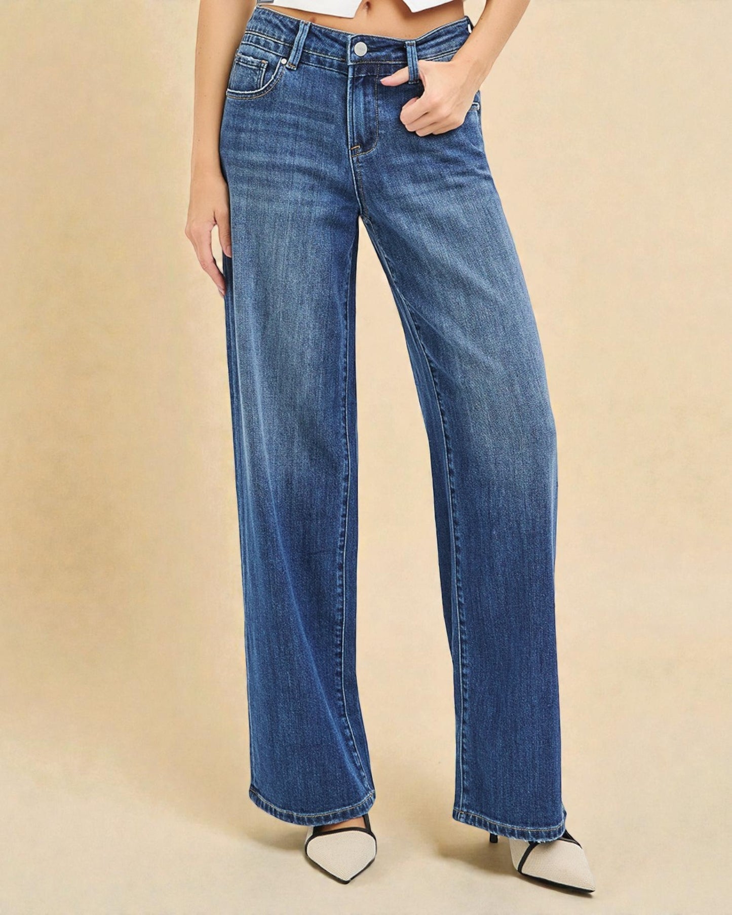 Person wearing blue jeans on a beige background