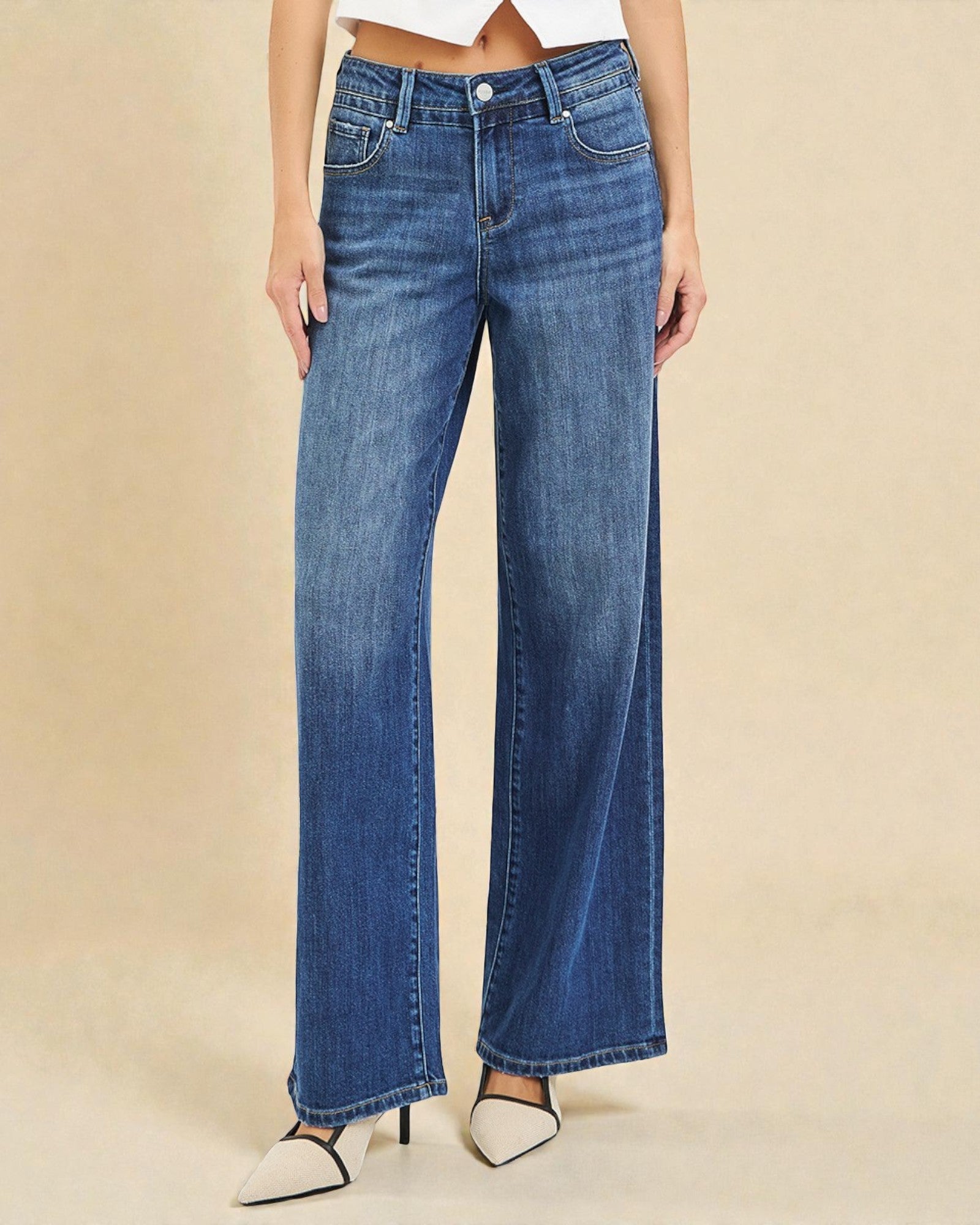 Blue jeans worn by a person on a beige background