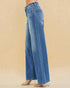 Blue jeans worn by a person on a beige background