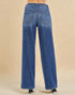 Blue jeans worn by a person on a beige background