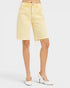 Yellow denim shorts worn by a person on a white background