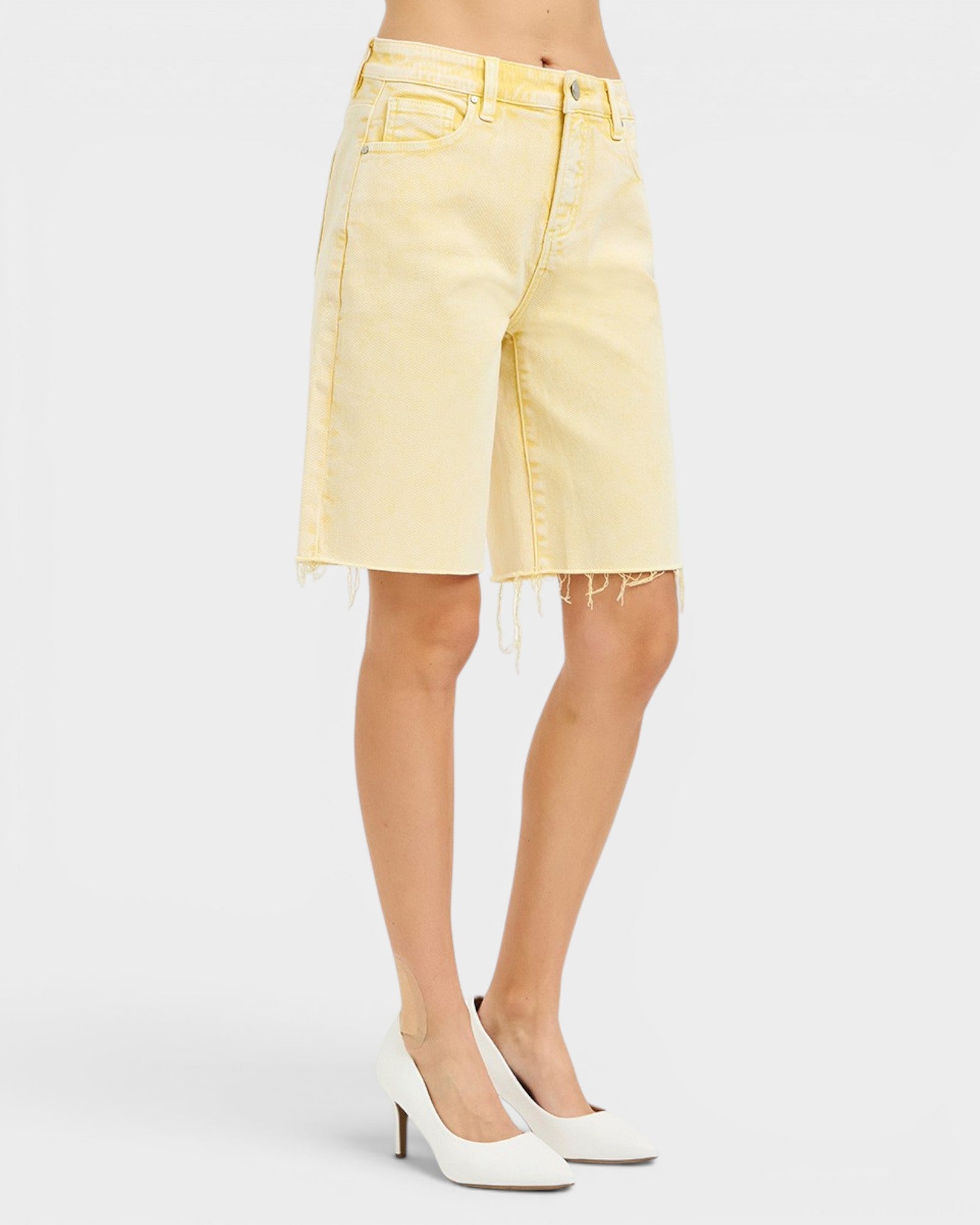 Light yellow denim skirt worn by a person on a white background