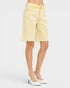 Light yellow denim skirt worn by a person on a white background