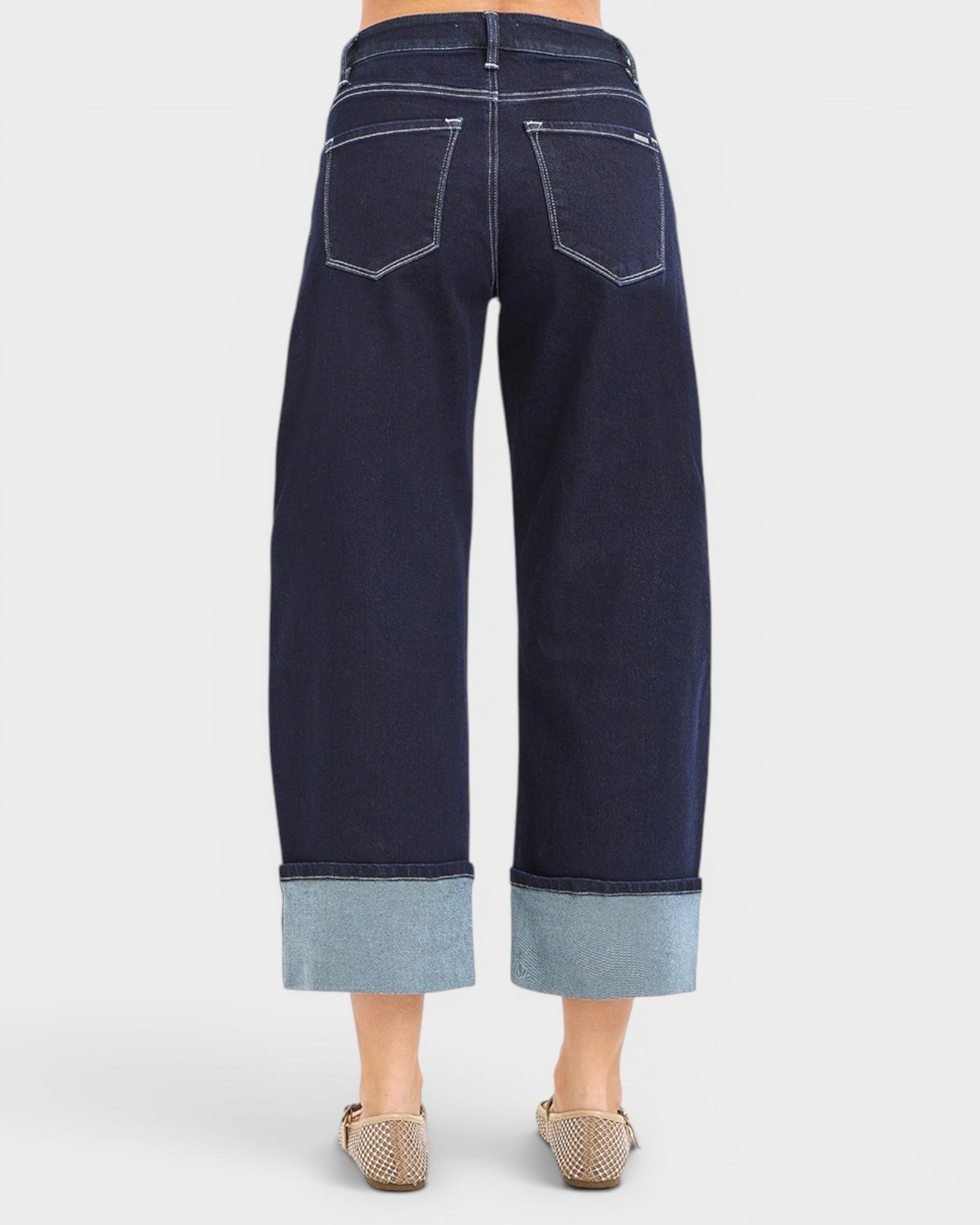 Navy blue jeans with cuffed hem on a white background