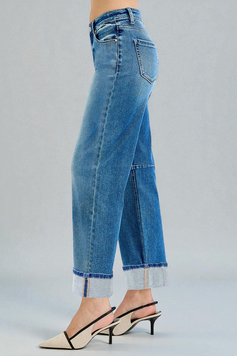 Blue jeans with a rolled hem on a gray background