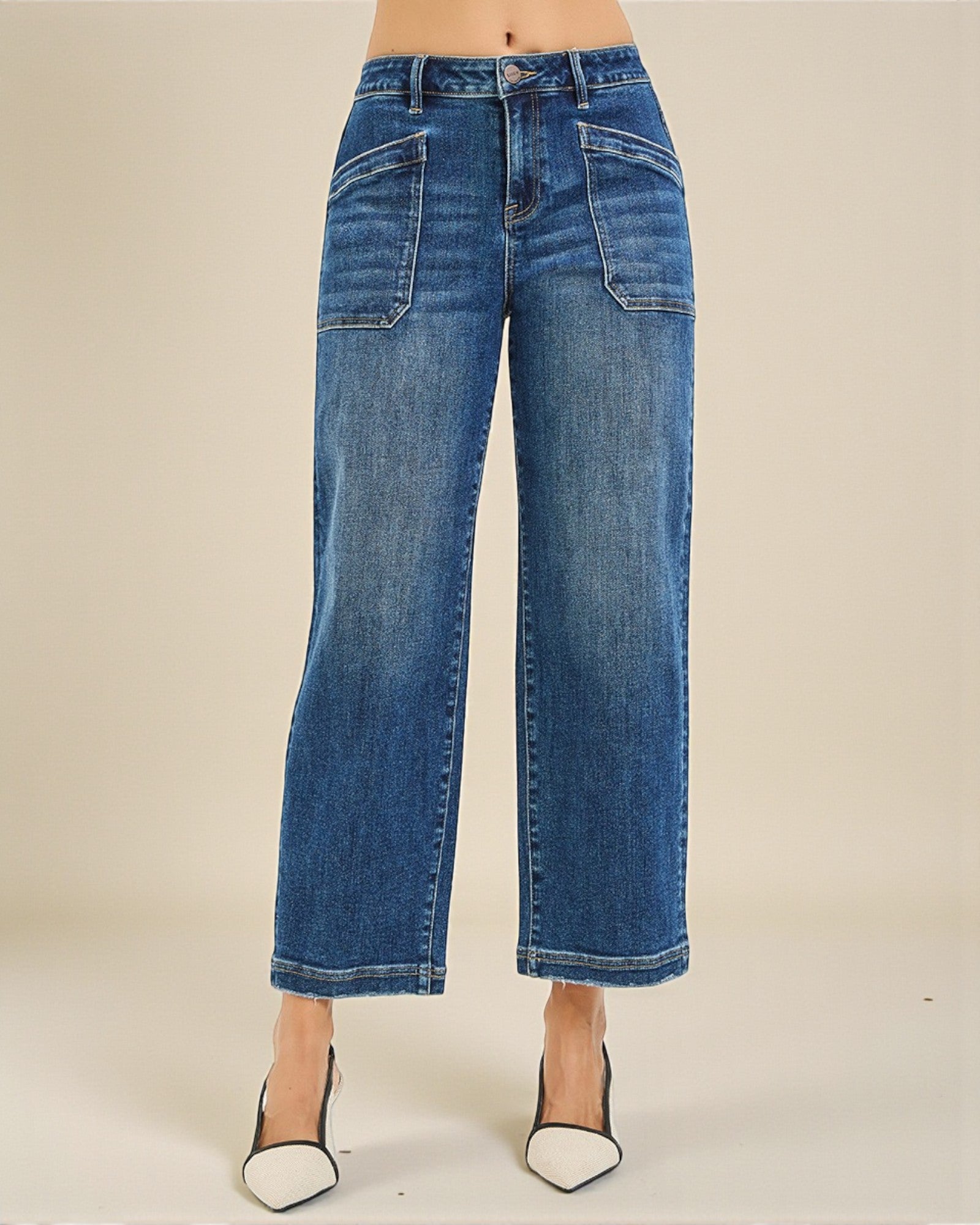 Blue jeans worn by a person on a plain background