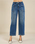 Blue jeans worn by a person on a plain background