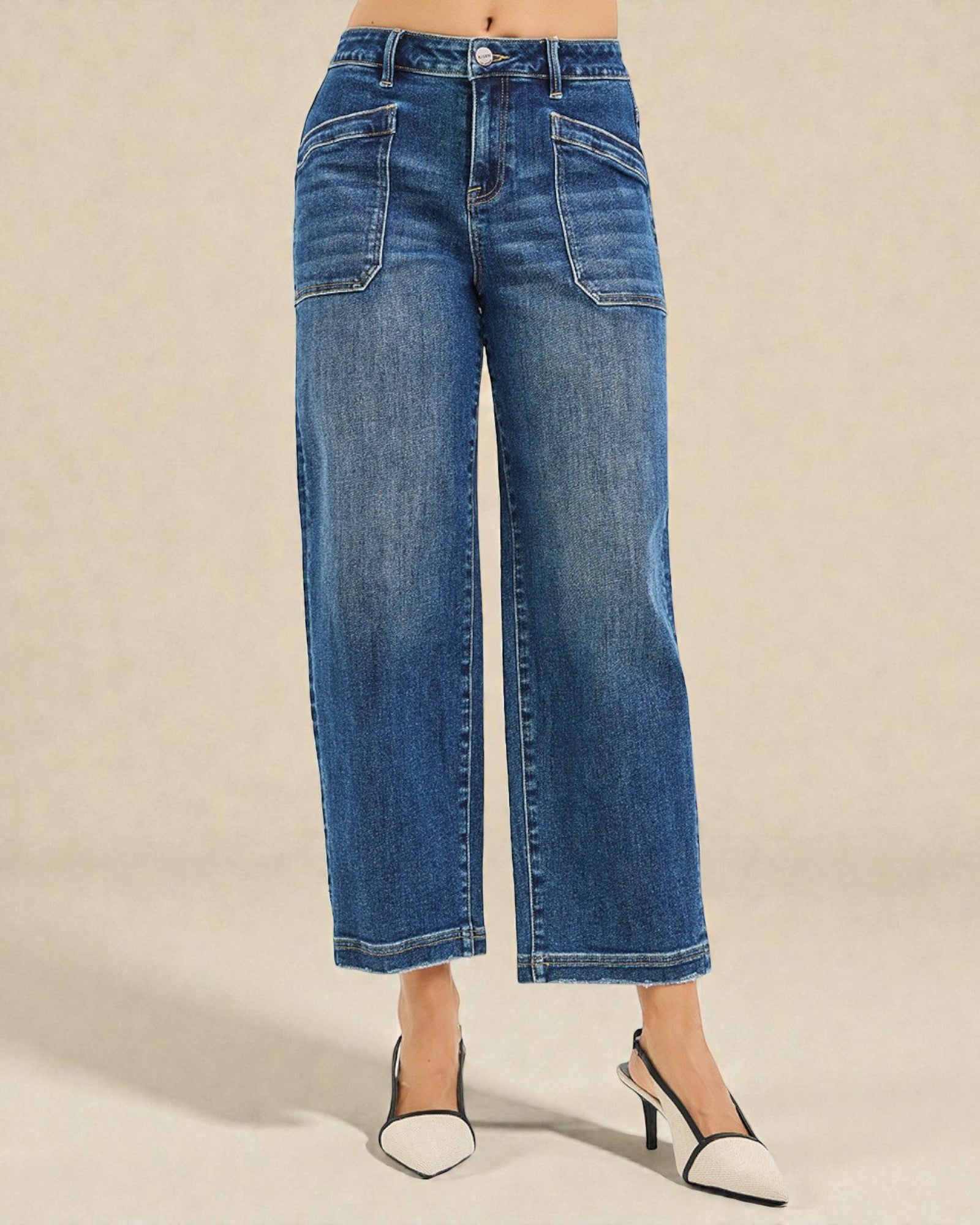 Blue jeans worn by a person on a beige background