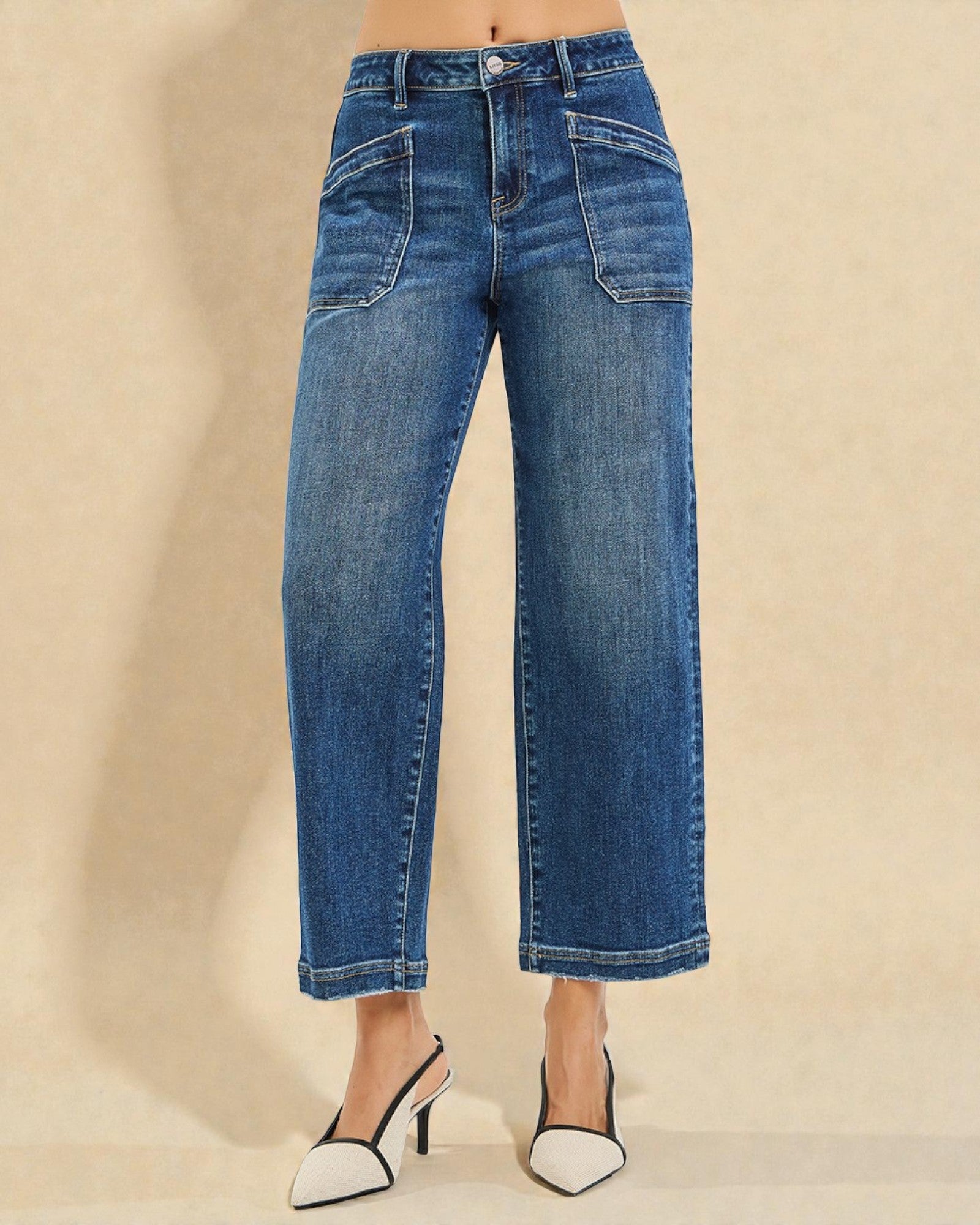 Blue jeans worn by a person on a beige background