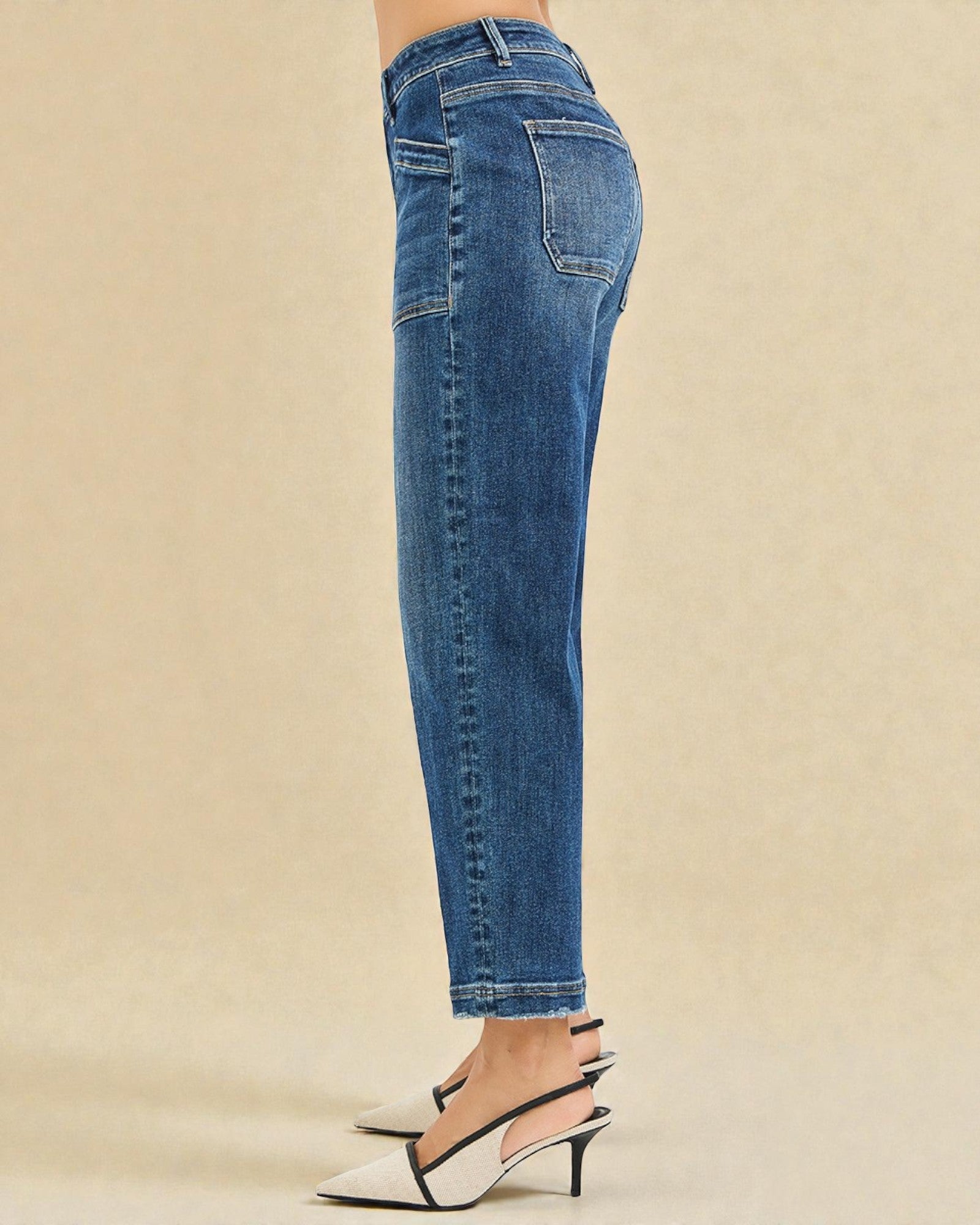 Blue jeans worn by a person on a beige background